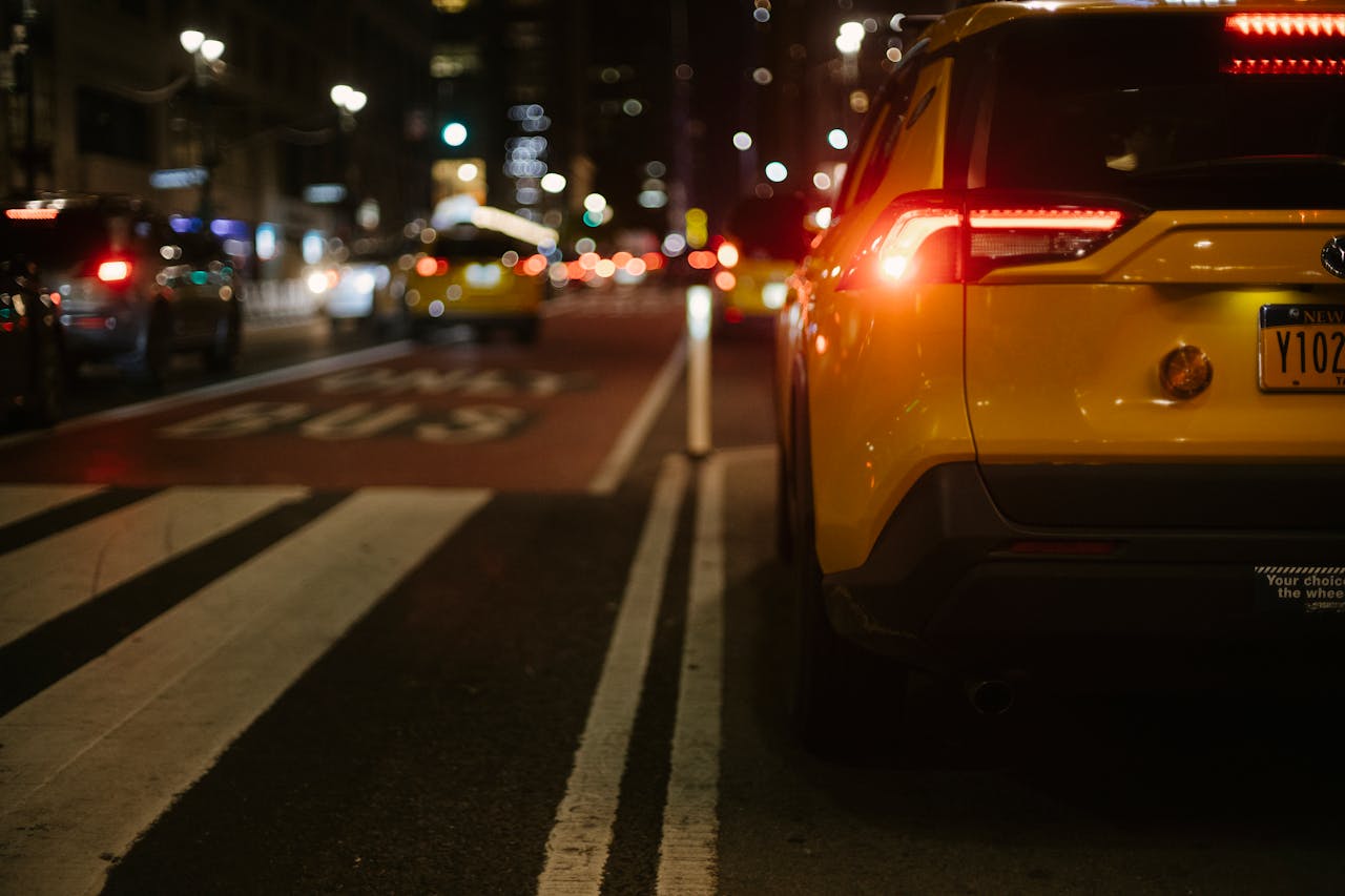 Stylish yellow SUV automobile driving on city street at night